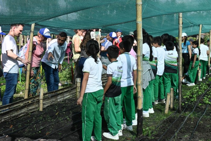Sol y Café’s General Manager Gerardo Alarcón Cubas (third from left) and the students of the cooperative’s school, explain to Oikocredit investors what they are growing at their nursery article 2